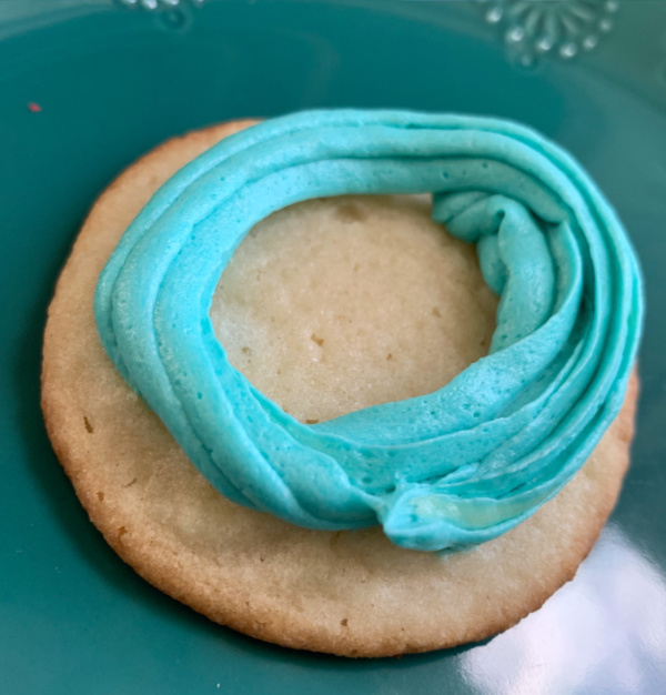 blue buttercream on a sugar cookie